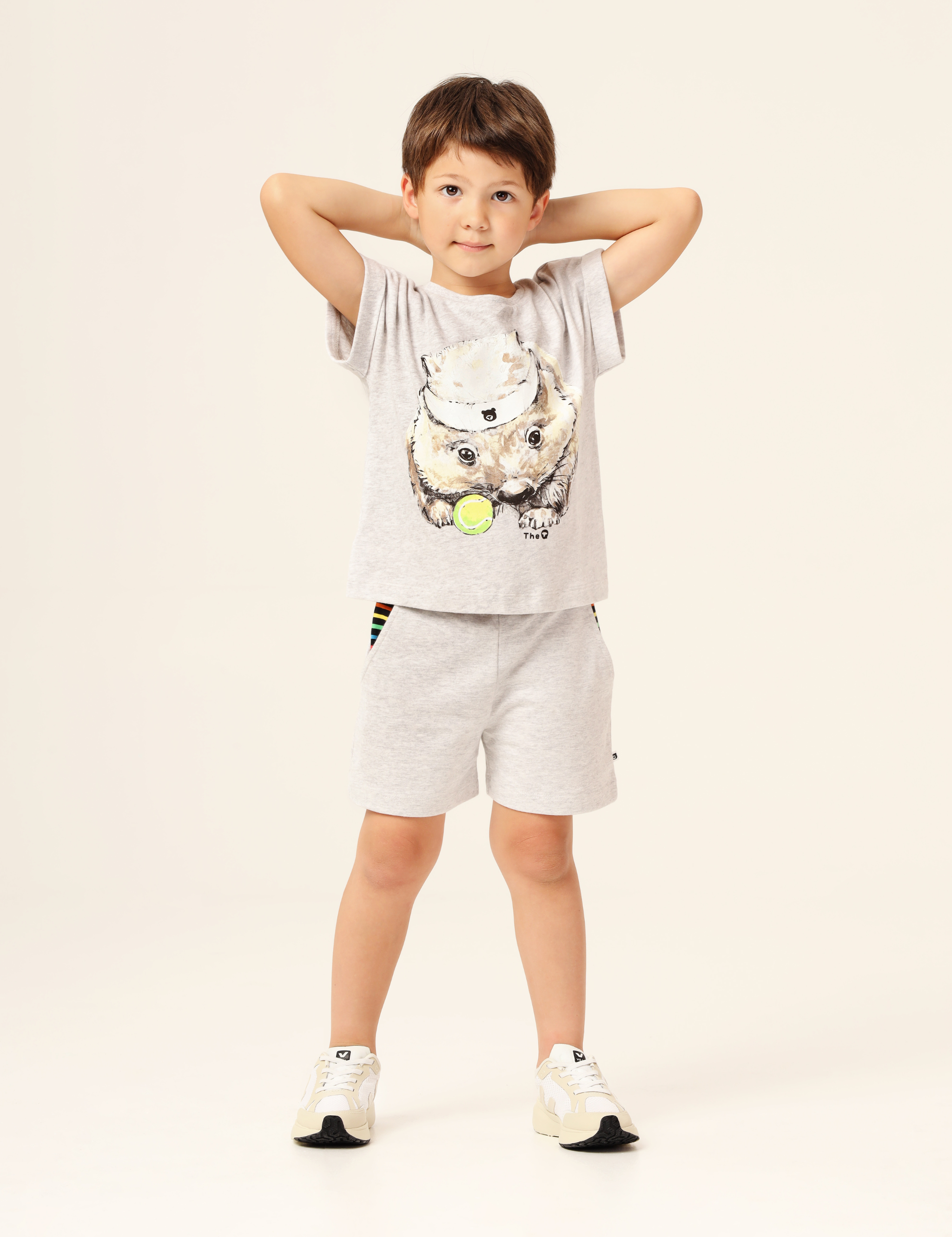 Child wearing light grey unisex shorts with rainbow stripe pocket lining, made from soft GOTS-certified organic cotton terry — comfortable and perfect for everyday adventures.