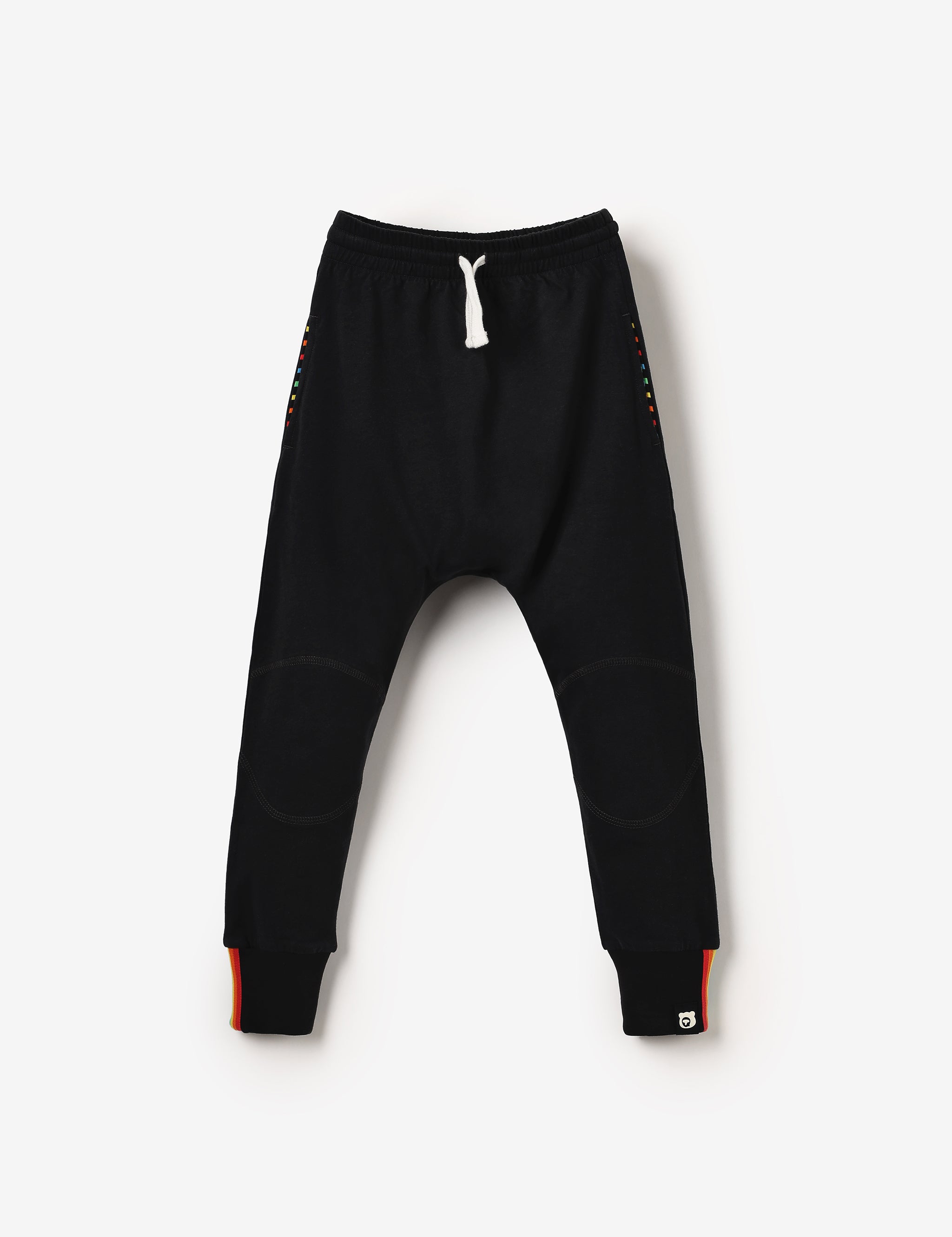 Flat lay of black kids joggers with knee patches, made from soft GOTS-certified organic cotton jersey – unisex, sensory-friendly, comfy and perfect for any adventure.